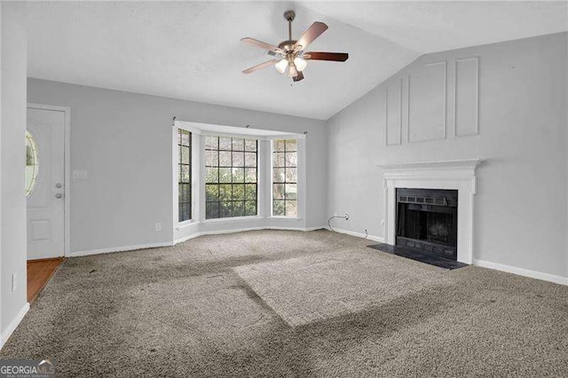 2895 Wildflower Ln, Snellville, GA 30039 - unfurnished living room featuring ceiling fan, carpet floors, a fireplace with flush hearth, and vaulted ceiling