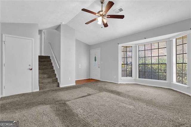 2895 Wildflower Ln, Snellville, GA 30039 - unfurnished living room with carpet, a ceiling fan, vaulted ceiling, and stairway