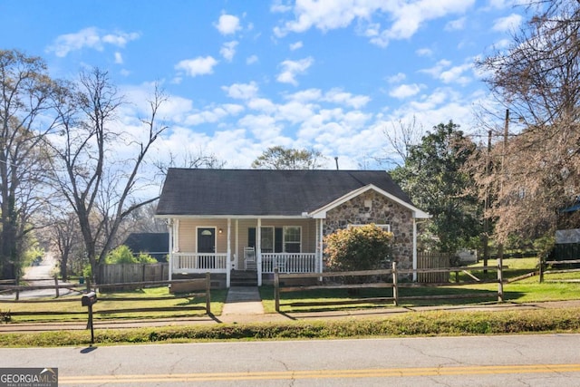 32 Martin Luther King Jr Dr, Commerce, GA 30529 - view of front of house with covered porch, a fenced front yard, a front lawn, and stone siding