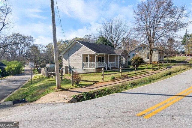 32 Martin Luther King Jr Dr, Commerce, GA 30529 - view of front facade with fence, covered porch, a front lawn, and crawl space