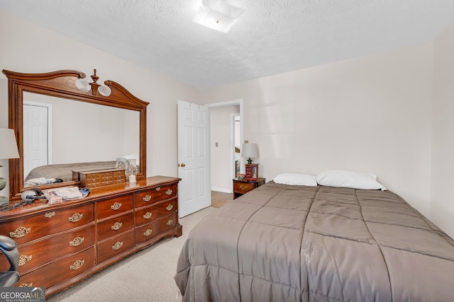 bedroom featuring a textured ceiling and light colored carpet