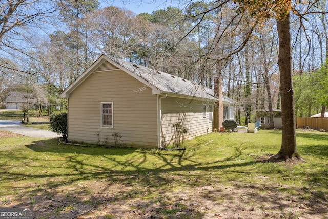 view of property exterior featuring fence and a yard