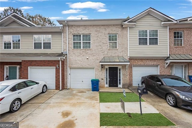 5027 Lower Elm St, Atlanta, GA 30349 - townhome / multi-family property featuring driveway, an attached garage, and brick siding