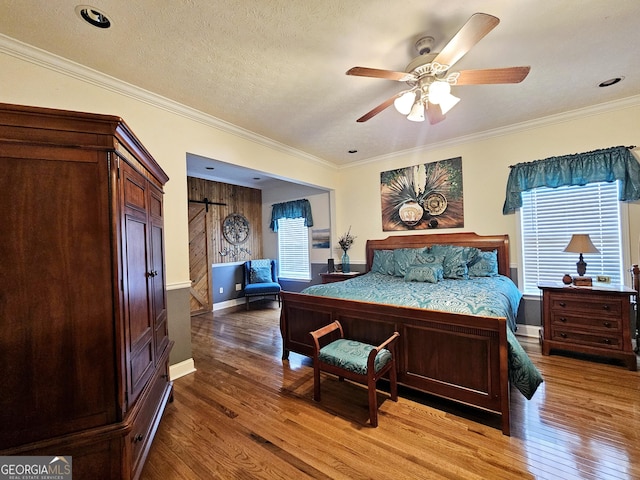 403 Holiday Rd, Franklin, GA 30217 - bedroom featuring ornamental molding, a textured ceiling, a barn door, and wood finished floors