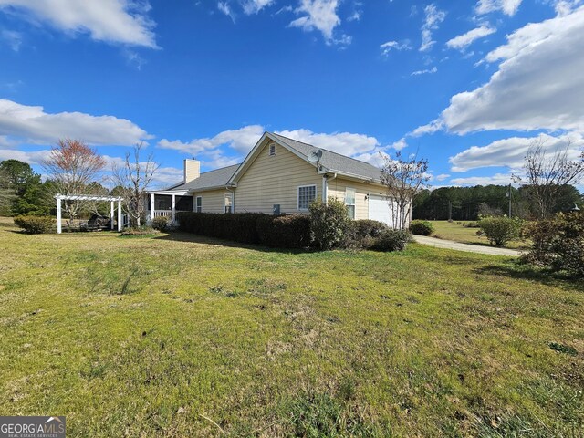 403 Holiday Rd, Franklin, GA 30217 - view of side of home with a lawn, a chimney, an attached garage, and a pergola