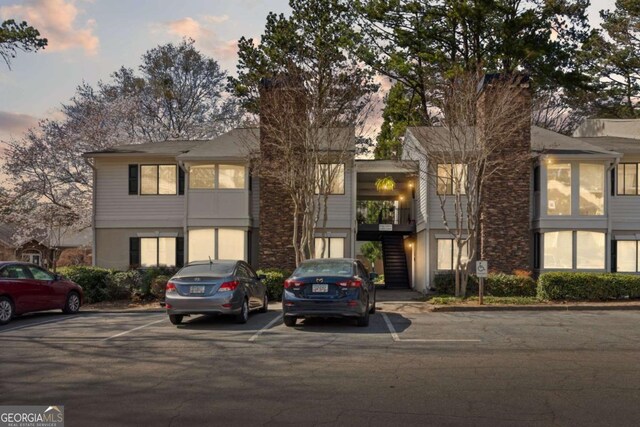 view of front facade featuring stairs and uncovered parking