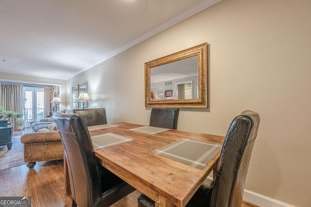 dining area featuring ornamental molding and wood finished floors