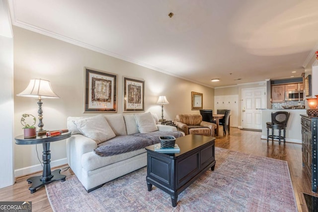 living area featuring crown molding, french doors, and wood finished floors