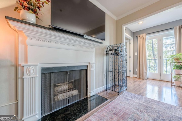 living room featuring baseboards, ornamental molding, and wood finished floors