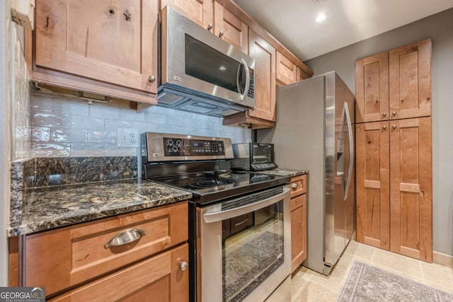3201 Lenox Rd NE Unit 16, Atlanta, GA 30324 - kitchen featuring stainless steel appliances, backsplash, dark stone counters, and light tile patterned floors