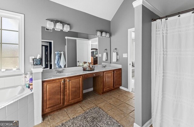 310 Persimmon Dr, Sharpsburg, GA 30277 - full bathroom featuring double vanity, plenty of natural light, lofted ceiling, tiled tub, and tile patterned flooring