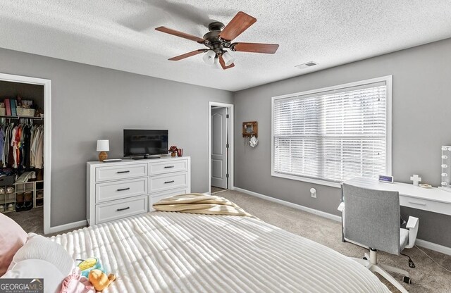 310 Persimmon Dr, Sharpsburg, GA 30277 - bedroom featuring light colored carpet, a spacious closet, a closet, ceiling fan, and a textured ceiling