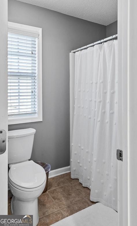 310 Persimmon Dr, Sharpsburg, GA 30277 - full bathroom featuring plenty of natural light, a textured ceiling, and curtained shower