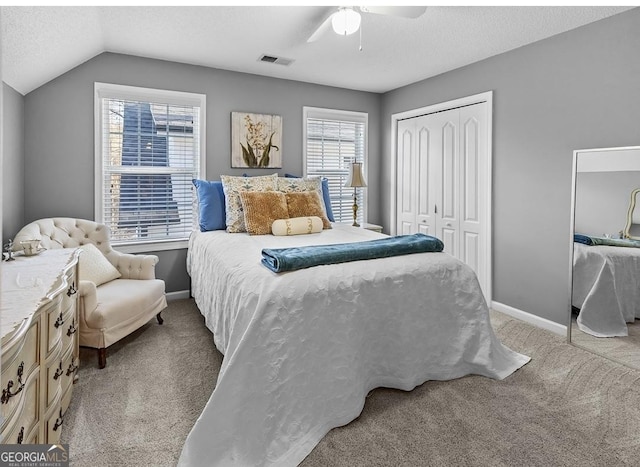 310 Persimmon Dr, Sharpsburg, GA 30277 - carpeted bedroom featuring a closet, multiple windows, lofted ceiling, ceiling fan, and a textured ceiling