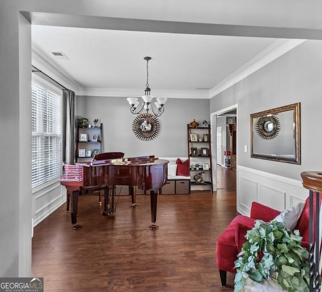 310 Persimmon Dr, Sharpsburg, GA 30277 - dining space featuring crown molding, wood finished floors, a chandelier, a decorative wall, and wainscoting