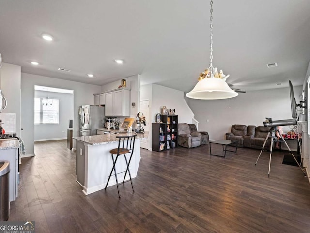 2027 Massey Ln, Winder, GA 30680 - kitchen featuring light stone countertops, open floor plan, dark wood finished floors, and freestanding refrigerator