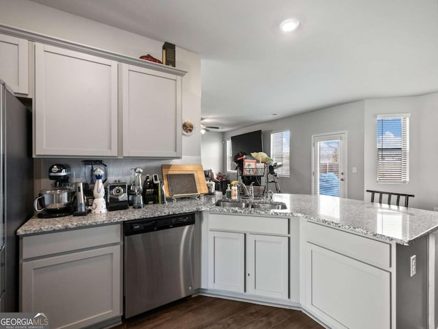 2027 Massey Ln, Winder, GA 30680 - kitchen featuring dark wood-style flooring, a peninsula, stainless steel dishwasher, freestanding refrigerator, and a sink