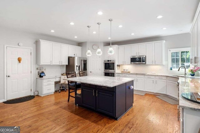 3015 Gold Creek Dr, Villa Rica, GA 30180 - kitchen with stainless steel appliances, white cabinetry, a kitchen island, decorative backsplash, and recessed lighting