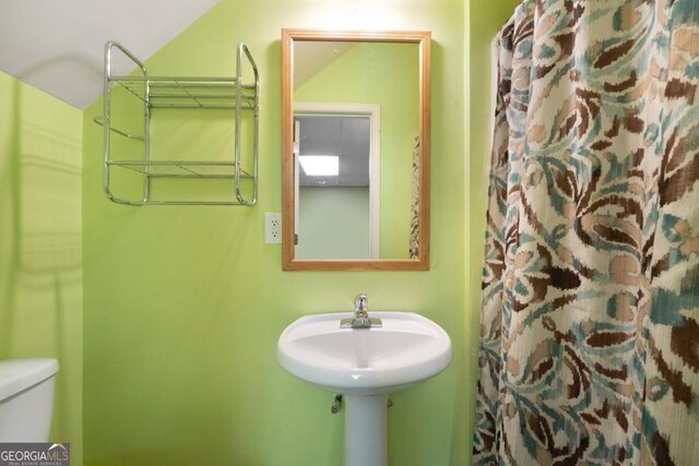 bathroom with curtained shower and toilet