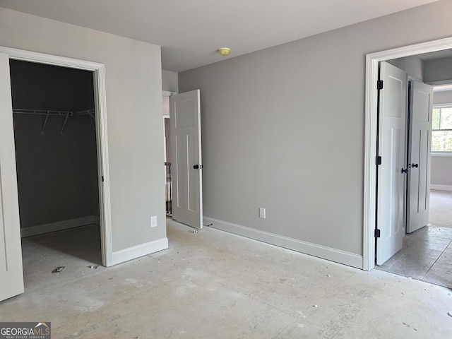 6841 Phillips Mill Rd, Douglasville, GA 30135 - unfurnished bedroom featuring a walk in closet, baseboards, and a closet