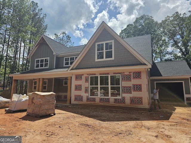 6841 Phillips Mill Rd, Douglasville, GA 30135 - back of property featuring roof with shingles, an attached garage, and a porch