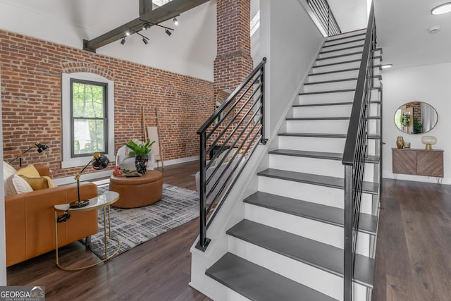 6592 Factory Shoals Rd SW, Mableton, GA 30126 - staircase with brick wall, wood finished floors, a high ceiling, and baseboards
