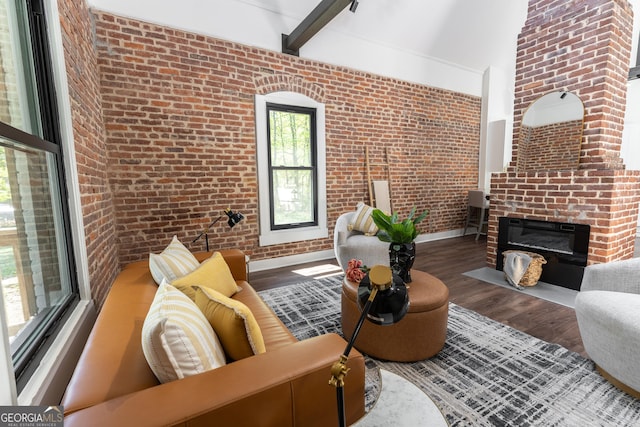 6592 Factory Shoals Rd SW, Mableton, GA 30126 - living area featuring brick wall, wood finished floors, a brick fireplace, baseboards, and a high ceiling