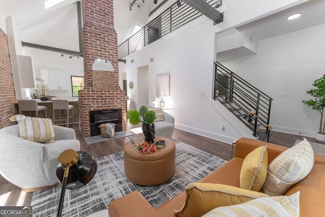 6592 Factory Shoals Rd SW, Mableton, GA 30126 - living area with stairway, wood finished floors, baseboards, a brick fireplace, and a towering ceiling