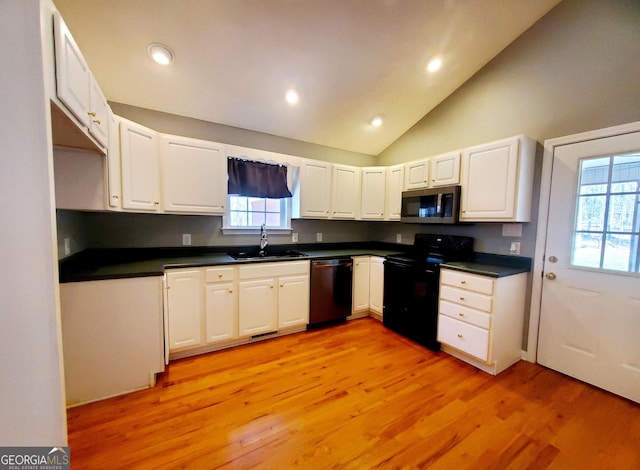 kitchen with a sink, stainless steel microwave, light wood-style floors, black electric range oven, and dishwasher