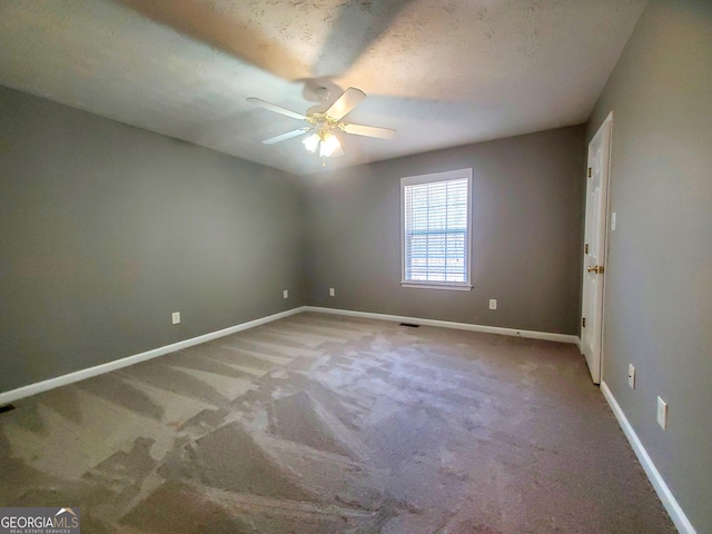 carpeted spare room featuring baseboards and ceiling fan