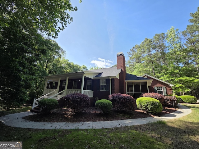 view of home's exterior featuring a chimney and a sunroom