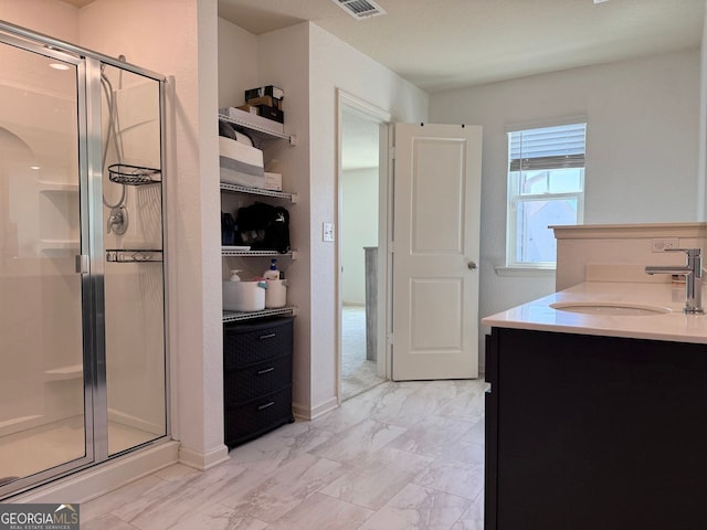 full bathroom with a stall shower, baseboards, vanity, and marble finish flooring
