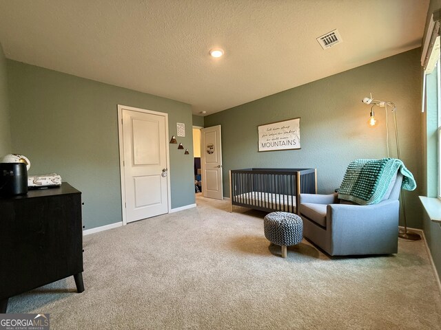bedroom with carpet flooring, baseboards, and a textured ceiling