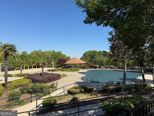 community pool featuring a gazebo and fence