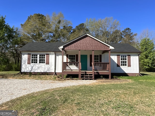 1350 Dogwood Rd, Woodville, GA 30669 - view of front facade featuring a front yard, covered porch, and board and batten siding