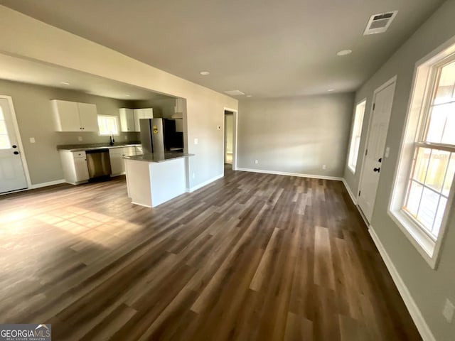 1350 Dogwood Rd, Woodville, GA 30669 - unfurnished living room with dark wood-style floors, baseboards, and visible vents