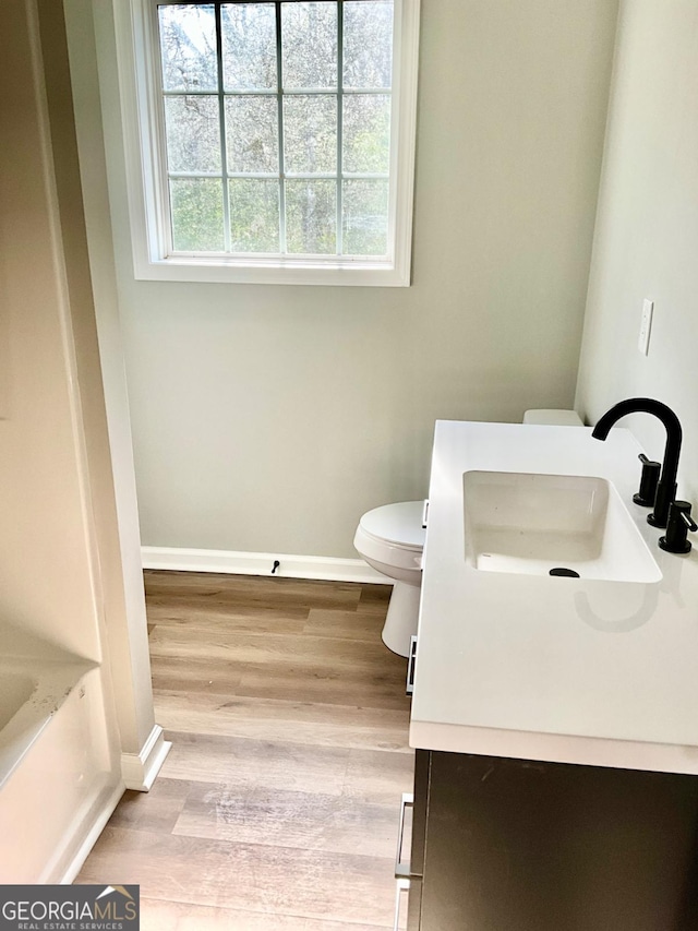 1350 Dogwood Rd, Woodville, GA 30669 - full bath with a washtub, baseboards, toilet, wood finished floors, and vanity