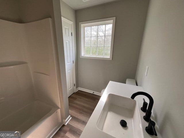 1350 Dogwood Rd, Woodville, GA 30669 - full bath with baseboards, tub / shower combination, a sink, and wood finished floors