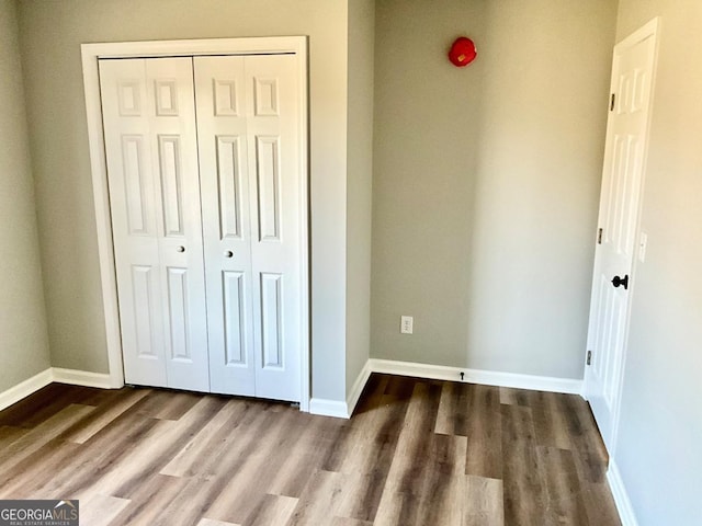 1350 Dogwood Rd, Woodville, GA 30669 - unfurnished bedroom featuring a closet, baseboards, and wood finished floors