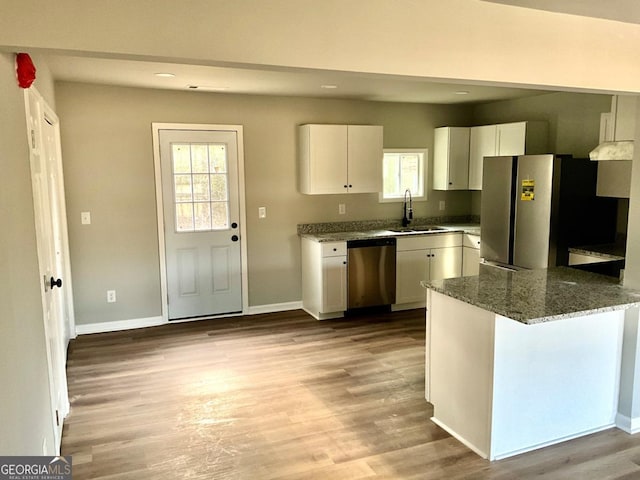 1350 Dogwood Rd, Woodville, GA 30669 - kitchen featuring white cabinetry, dark stone countertops, a sink, light wood finished floors, and appliances with stainless steel finishes