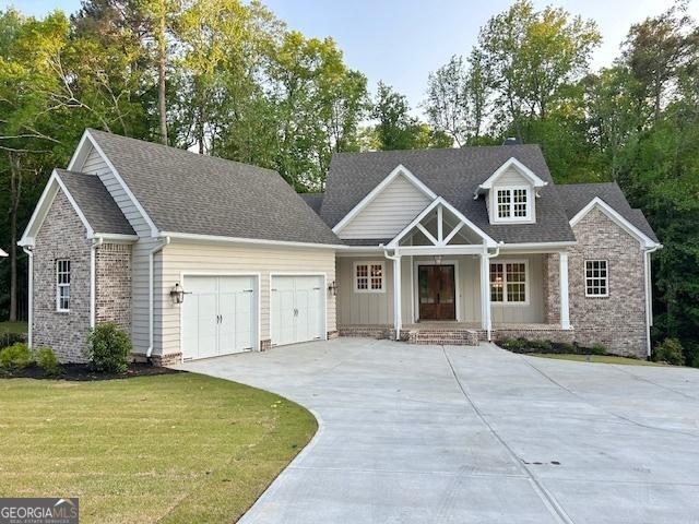7 Fontaine Dr, Newnan, GA 30263 - craftsman house featuring a garage, covered porch, driveway, a front lawn, and board and batten siding