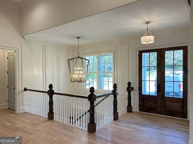7 Fontaine Dr, Newnan, GA 30263 - entryway with plenty of natural light, wood finished floors, a chandelier, french doors, and crown molding