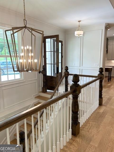 7 Fontaine Dr, Newnan, GA 30263 - stairway featuring a chandelier, wood finished floors, crown molding, and a decorative wall