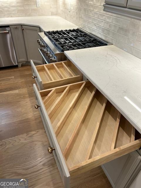7 Fontaine Dr, Newnan, GA 30263 - kitchen view of decorative backsplash, stainless steel dishwasher, wood finished floors, and gray cabinetry