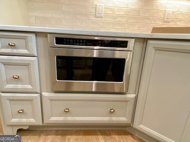 7 Fontaine Dr, Newnan, GA 30263 - detailed view of backsplash, oven, and white cabinets