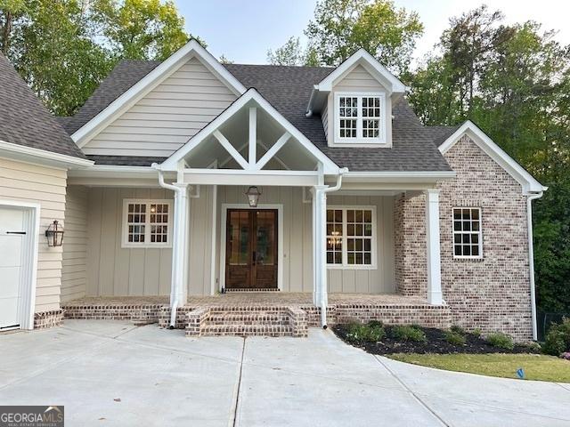 7 Fontaine Dr, Newnan, GA 30263 - view of front of house featuring a porch, french doors, board and batten siding, and roof with shingles
