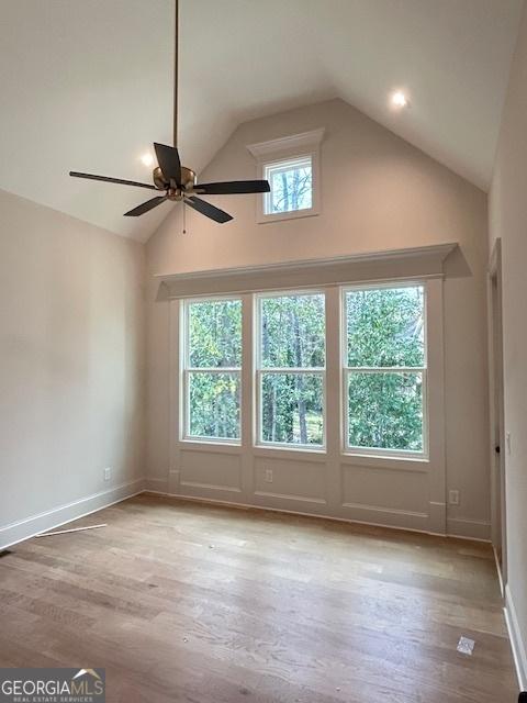 7 Fontaine Dr, Newnan, GA 30263 - empty room with ceiling fan, high vaulted ceiling, light wood-style floors, and baseboards