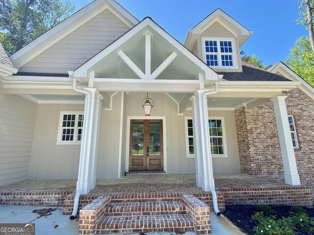 7 Fontaine Dr, Newnan, GA 30263 - property entrance featuring french doors, covered porch, board and batten siding, and brick siding