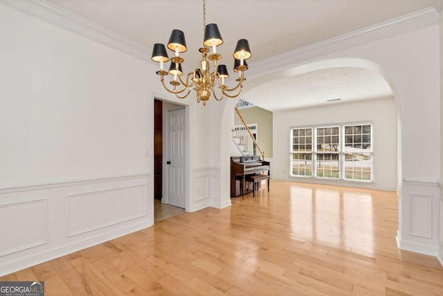 2002 Stonewick Ct, Lawrenceville, GA 30043 - unfurnished dining area featuring arched walkways, stairs, a chandelier, wood finished floors, and ornamental molding