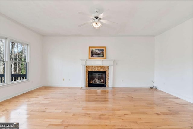 2002 Stonewick Ct, Lawrenceville, GA 30043 - unfurnished living room featuring ceiling fan, a high end fireplace, ornamental molding, and light wood finished floors